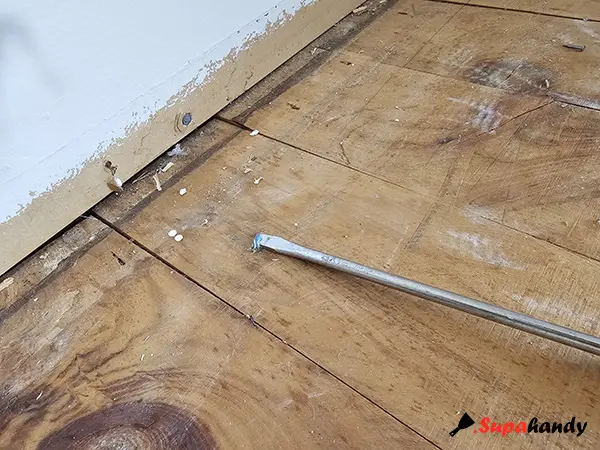 Remove staples with a screwdriver from the floorboard