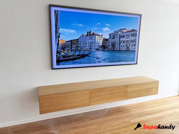 Wall-mounted flat TV above a floating TV cabinet